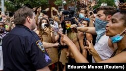 U.S. -- Demonstrators react in the presence of a New York Police Department (NYPD) police officer at a joint LGBTQ and Black Lives Matter march on the 51st anniversary of the Stonewall riots in New York City, New York, U.S. June 28, 2020. REUTERS/Eduardo 